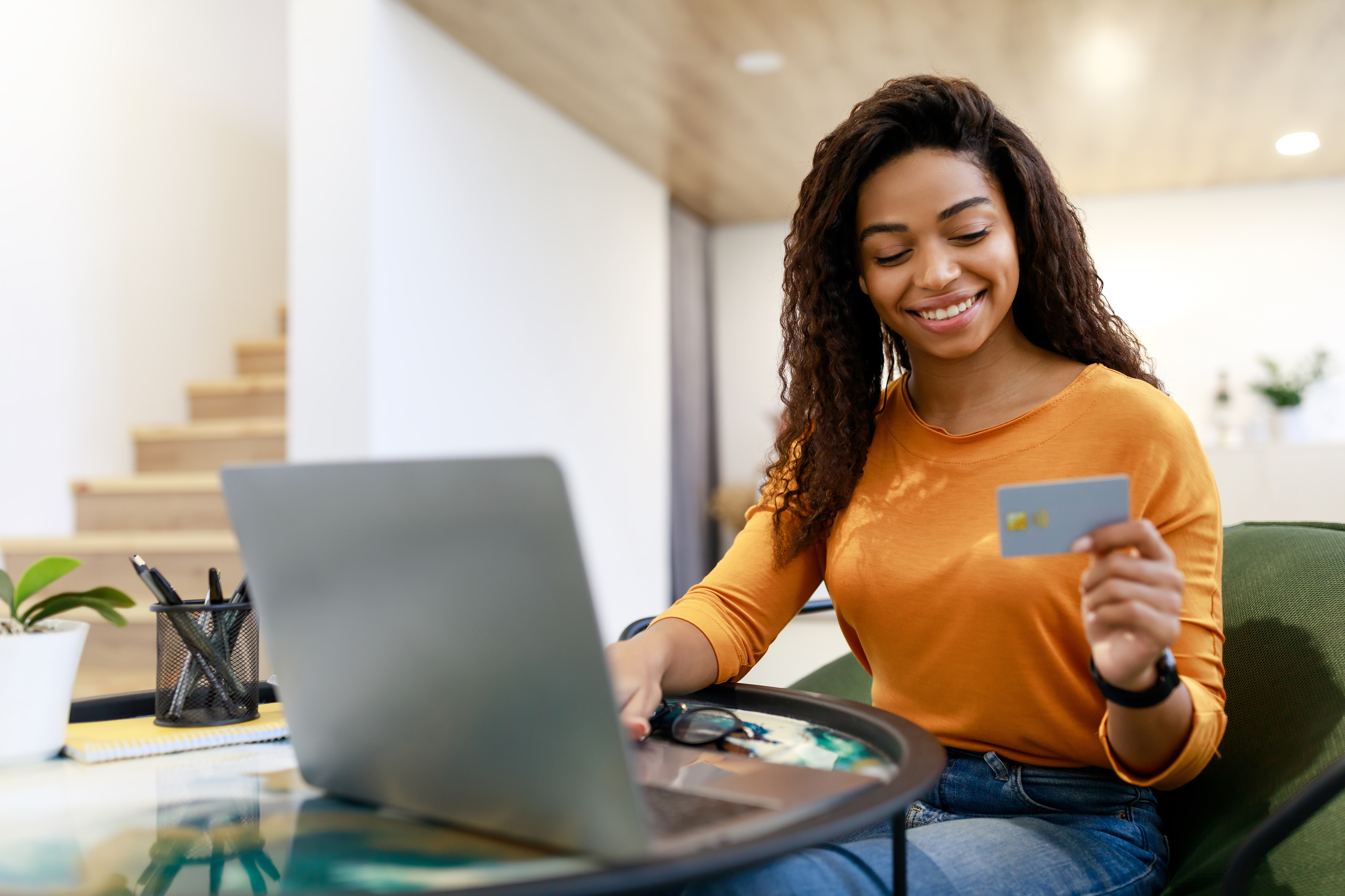 YHappy woman holding debit credit card, using pc
